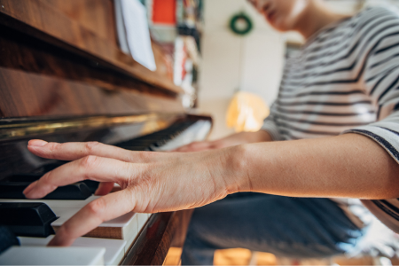 Iemand bespeelt een klassieke piano