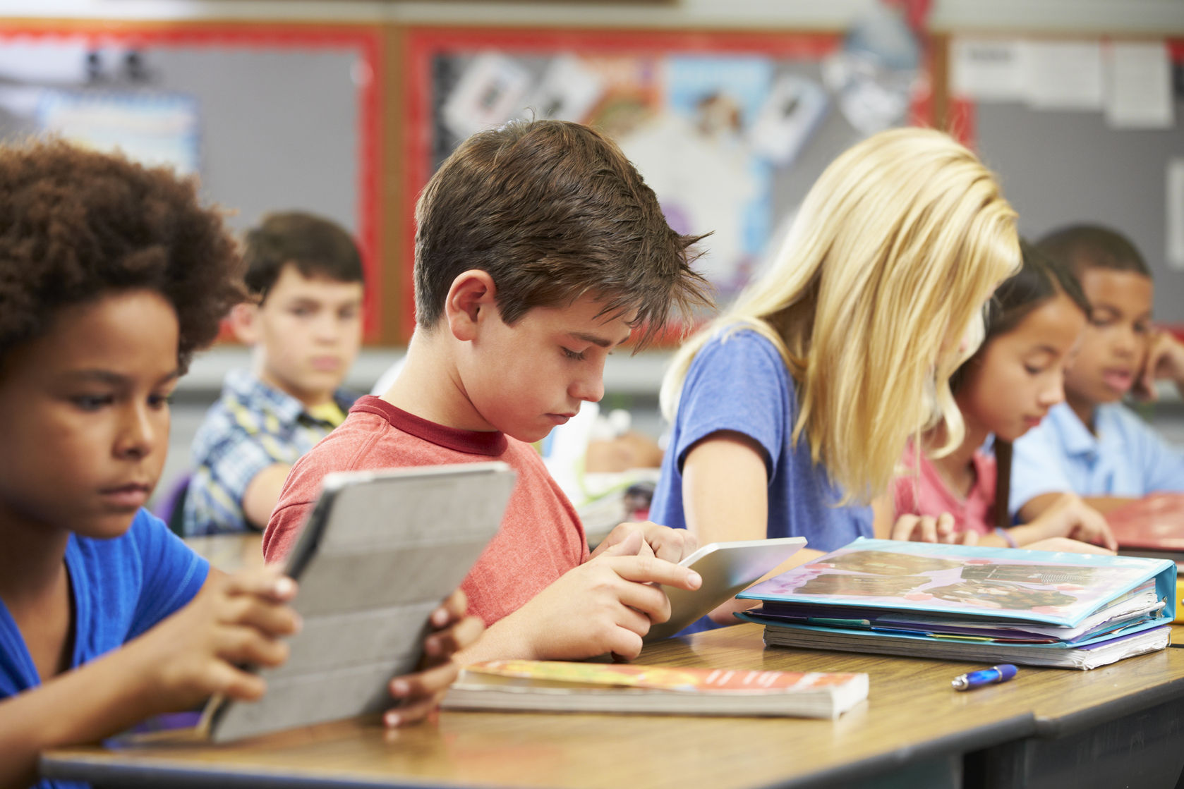 Scholieren in de klas met boeken in IPads