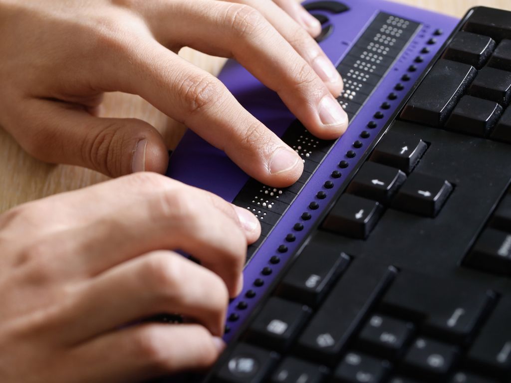 twee handen op een brailleleesregel