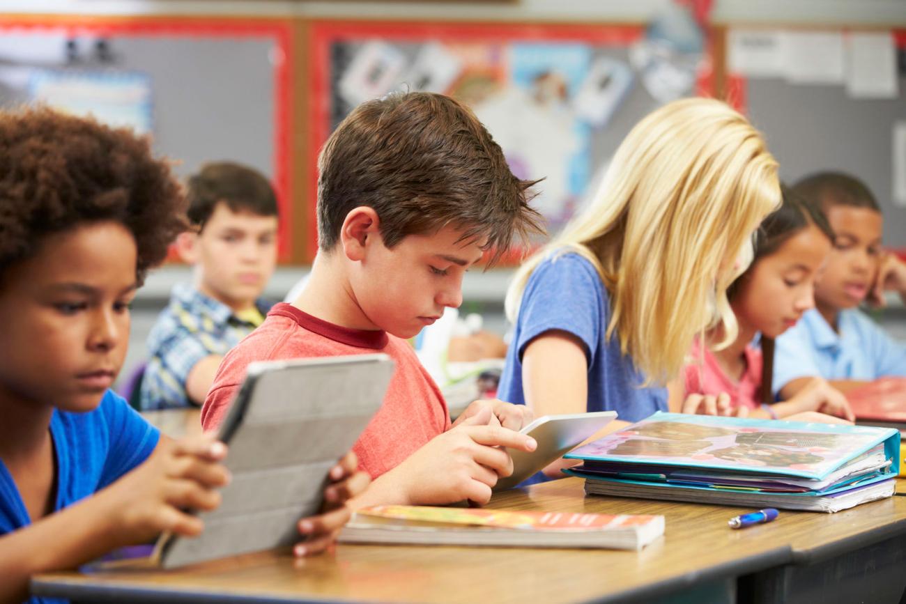 kinderen in een klas die op een tablet aan het lezen zijn