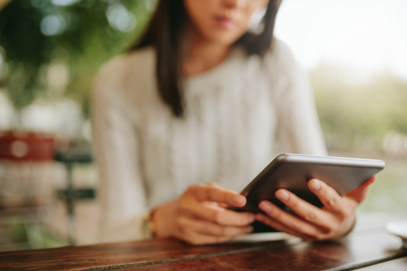 vrouw houdt ipad vast waarop ze iets leest