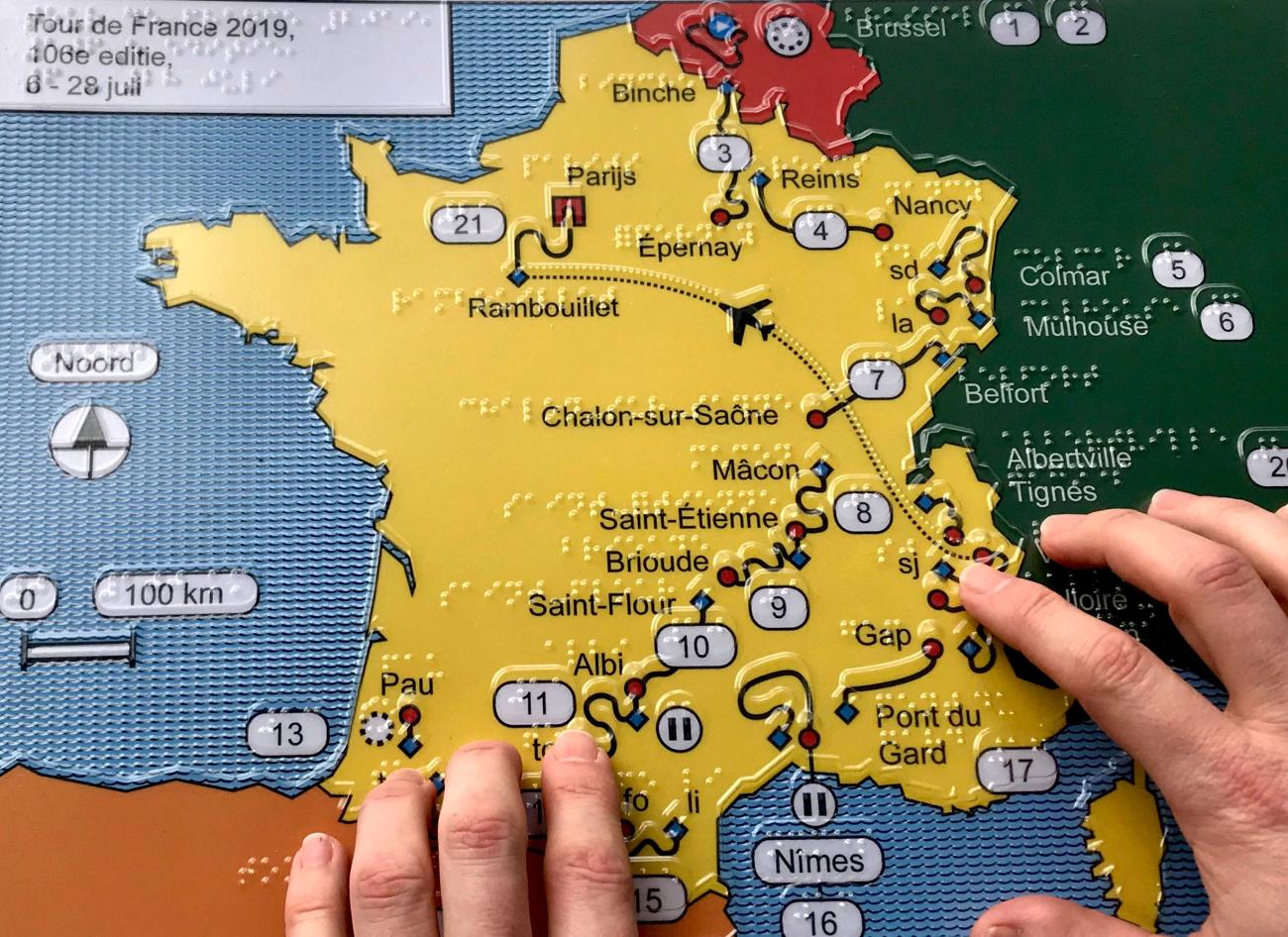 Handen voelen een overzichtskaart in reliëf van de Tour de France 2019