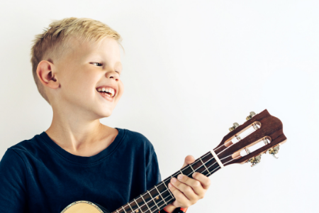 Kind bespeelt de ukelele